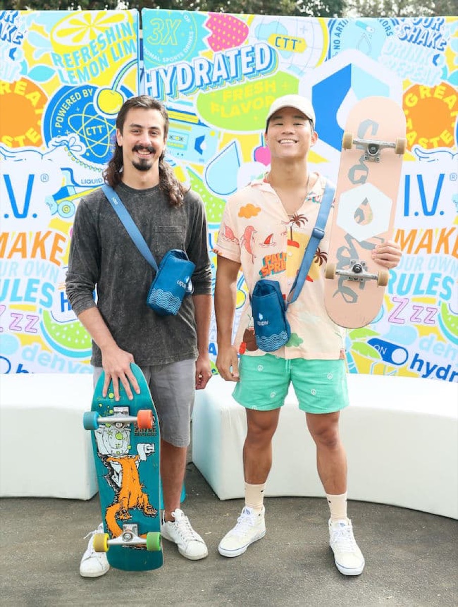 Two guests with skateboards at the Liquid I.V. step and repeat