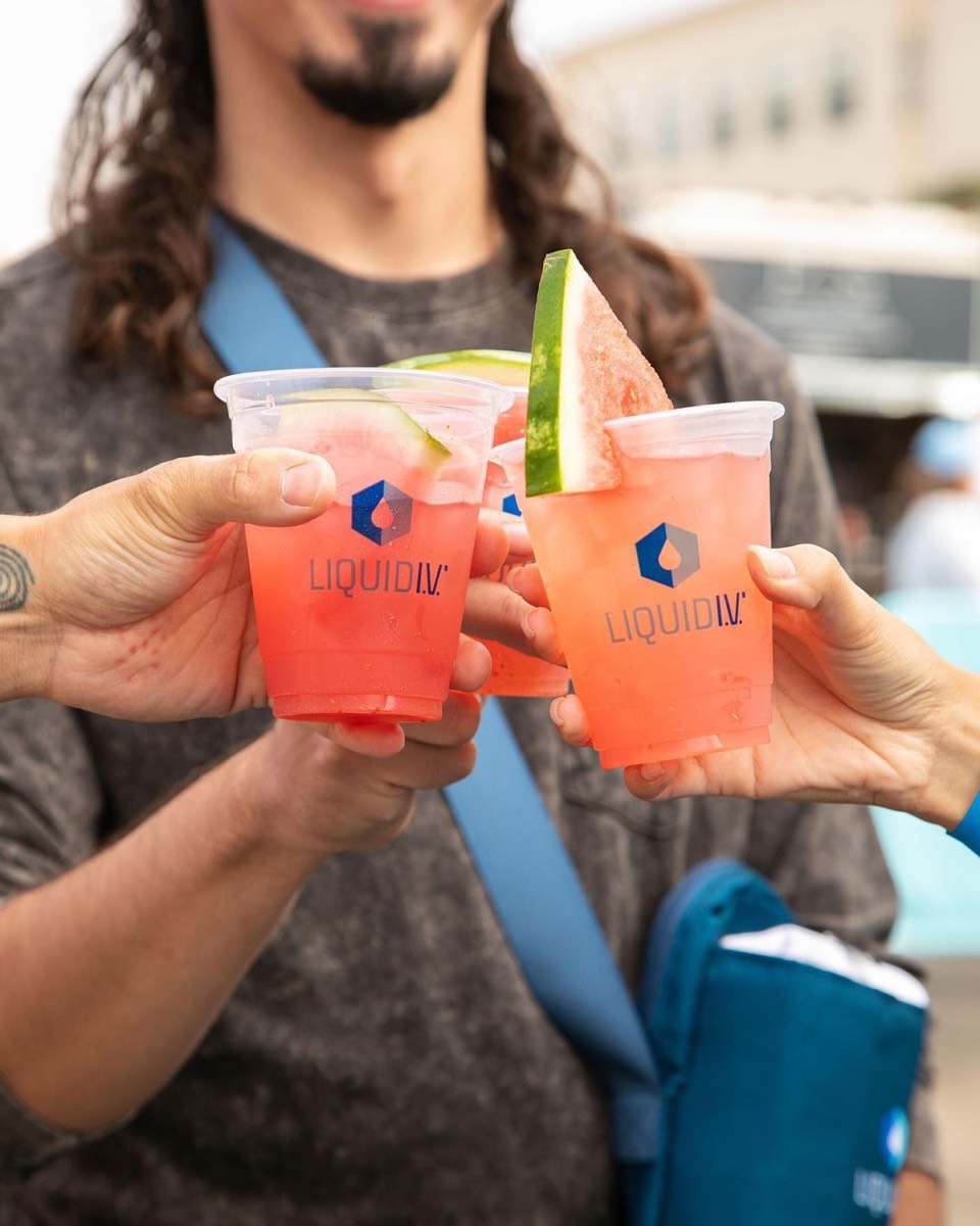 Two Liquid I.V. cocktails, garnished, being clinked