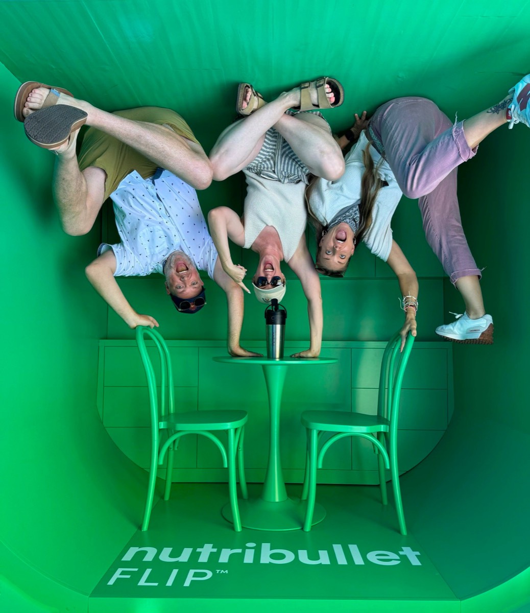 Three guests appearing to stand on the ceiling around a café table