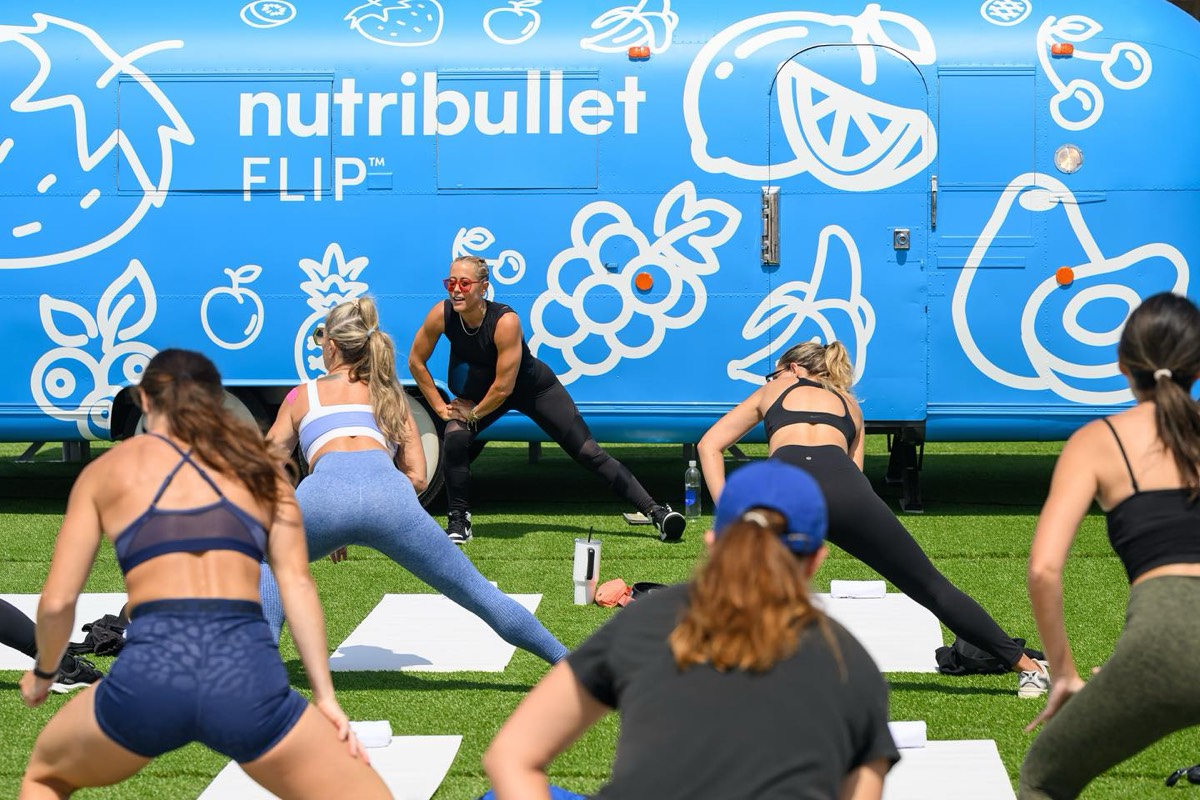 A yoga class on the lawn beside the NutriBullet Airstream