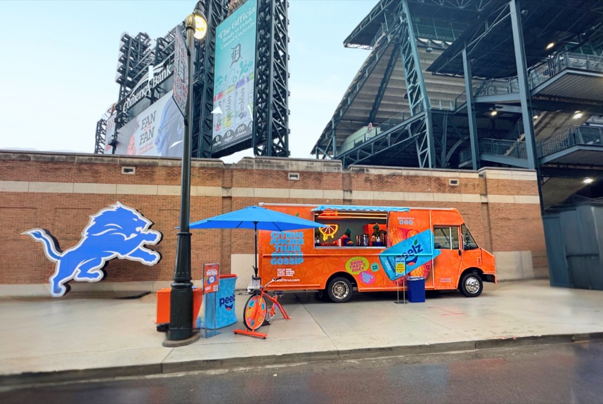 The Peelz truck outside Ford Field beside a Detroit Lions logo