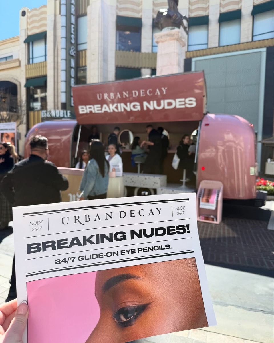 A Breaking Nudes flyer held up in front of the Airstream