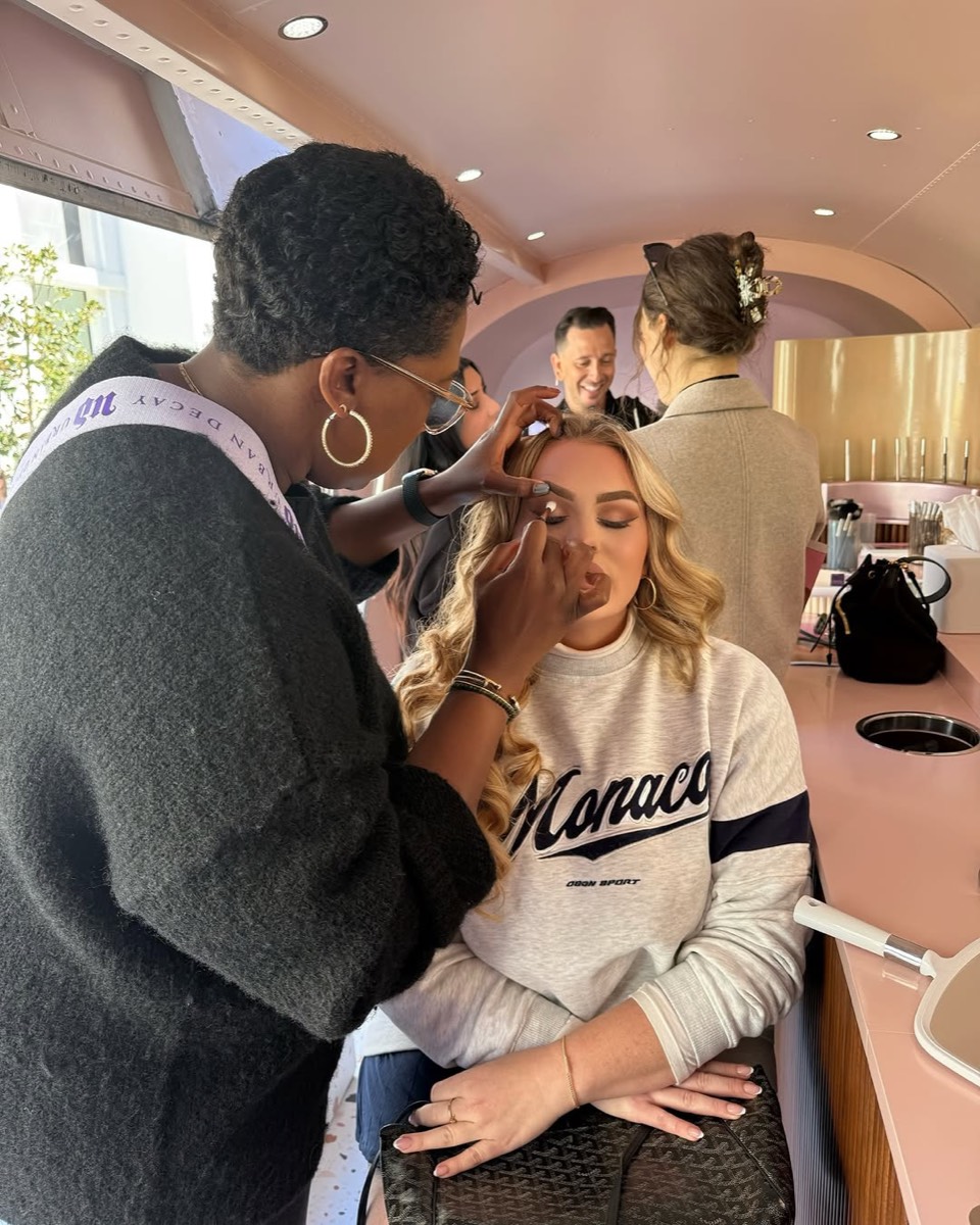 A guest having eye makeup applied inside the Airstream